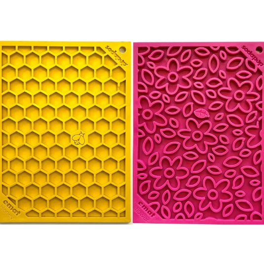 Two silicone mats, one yellow with honeycomb pattern and one pink with floral pattern, on a white background.